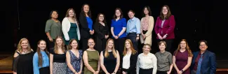 Group of women in STEM participants smiling and standing in front of a black backdrop