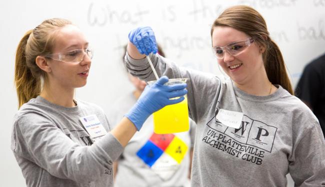 Two UW-Platteville alchemy club members collaborate on a chemistry-type project