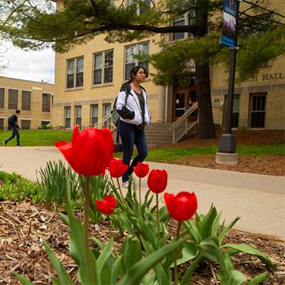 Student walking on campus in spring