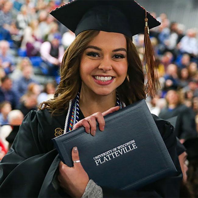 student at commencement with diploma
